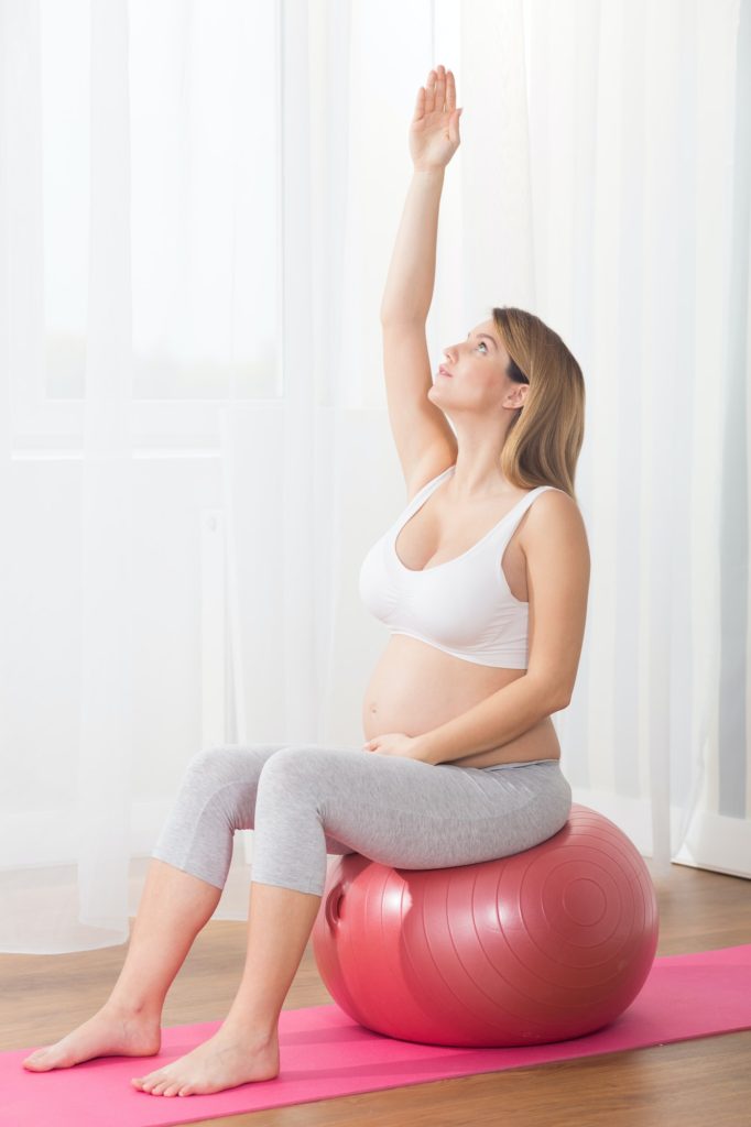 Beautiful pregnant woman doing exercises